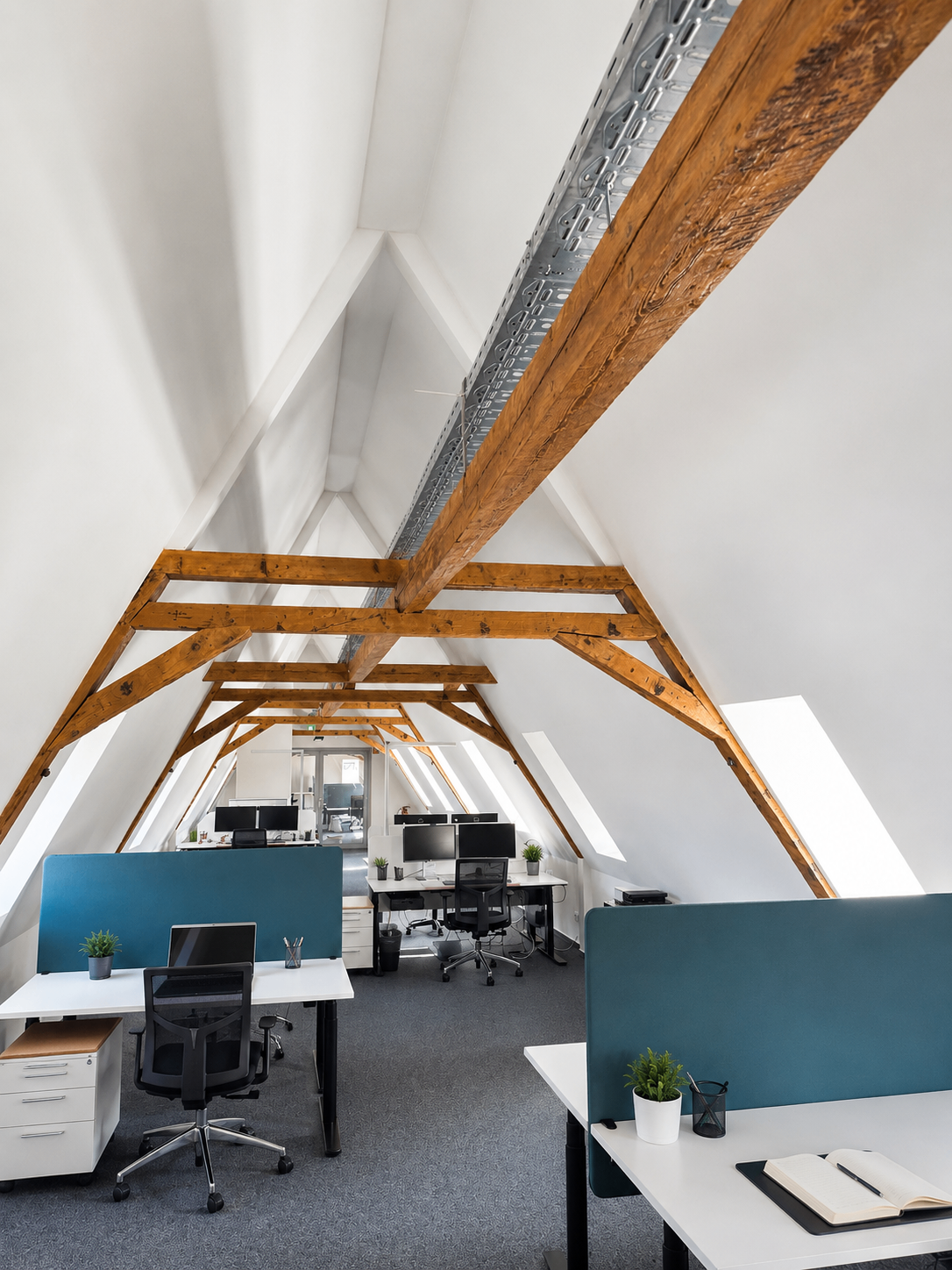 Heller Open Space unter dem Dach der BETA BOX Wetzlar mit Arbeitsplätzen und markanten Holzbalken