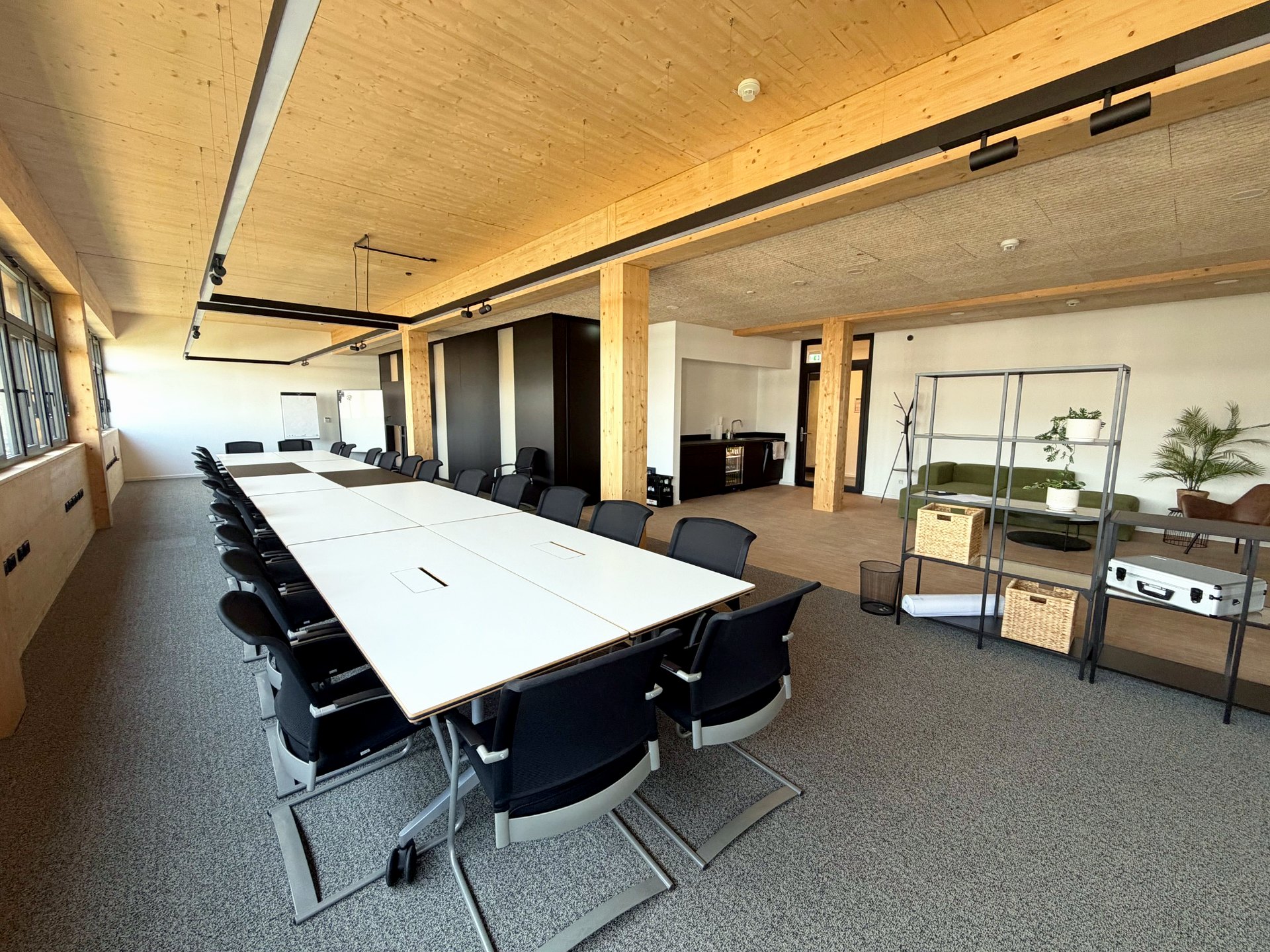 Seminarraum der THINKBOX mit Tagungstisch, Holzbau und angrenzendem Lounge-Bereich