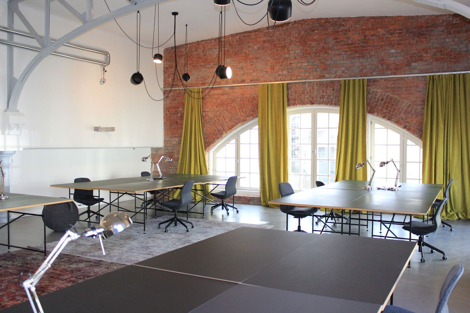 Großzügiger Meeting- und Seminarbereich der BETA BOX Gießen mit Backsteinwand und Tageslicht