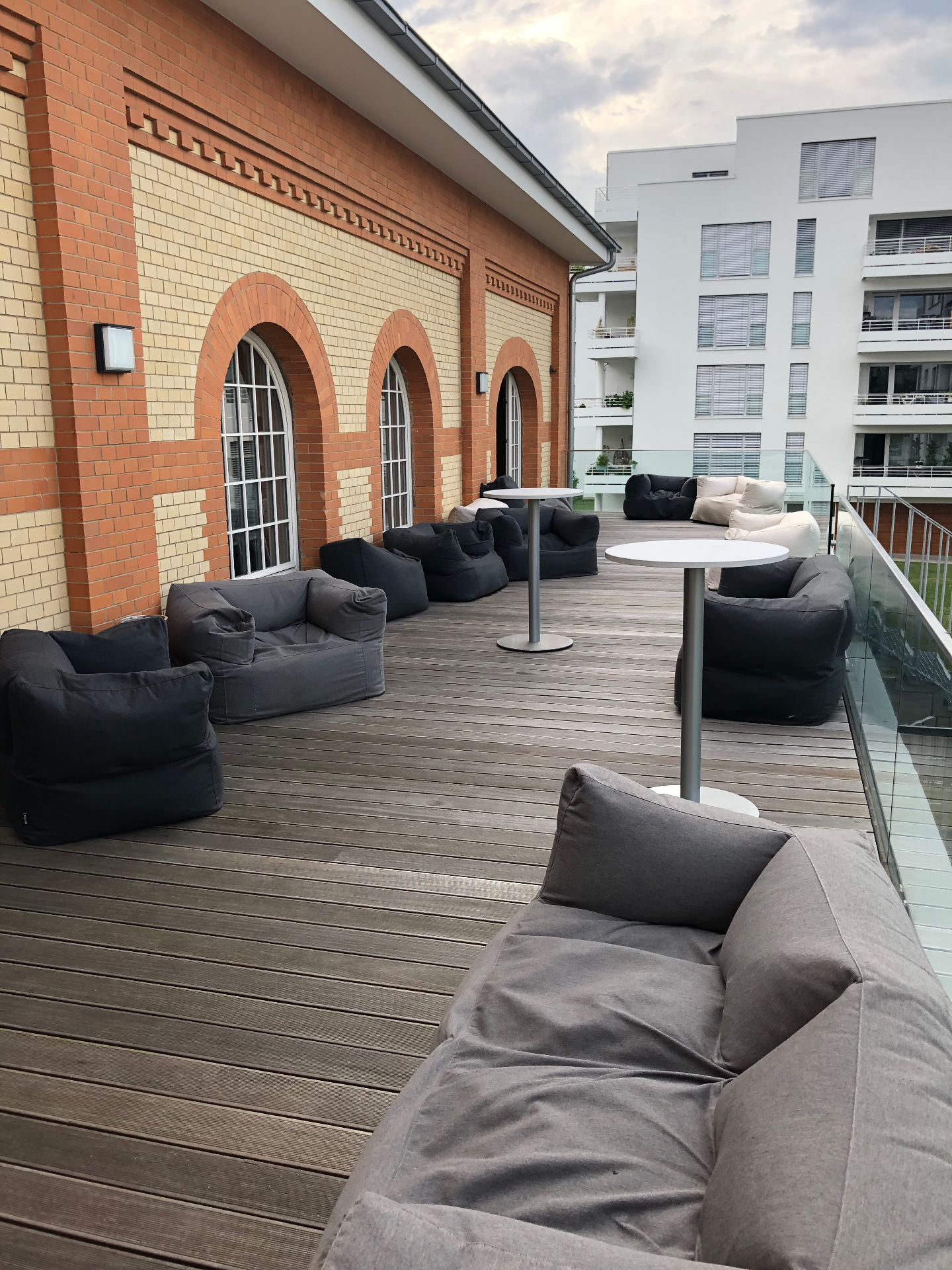 Terrasse der BETA BOX Gießen mit Sitzsäcken entlang der historischen Backsteinfassade