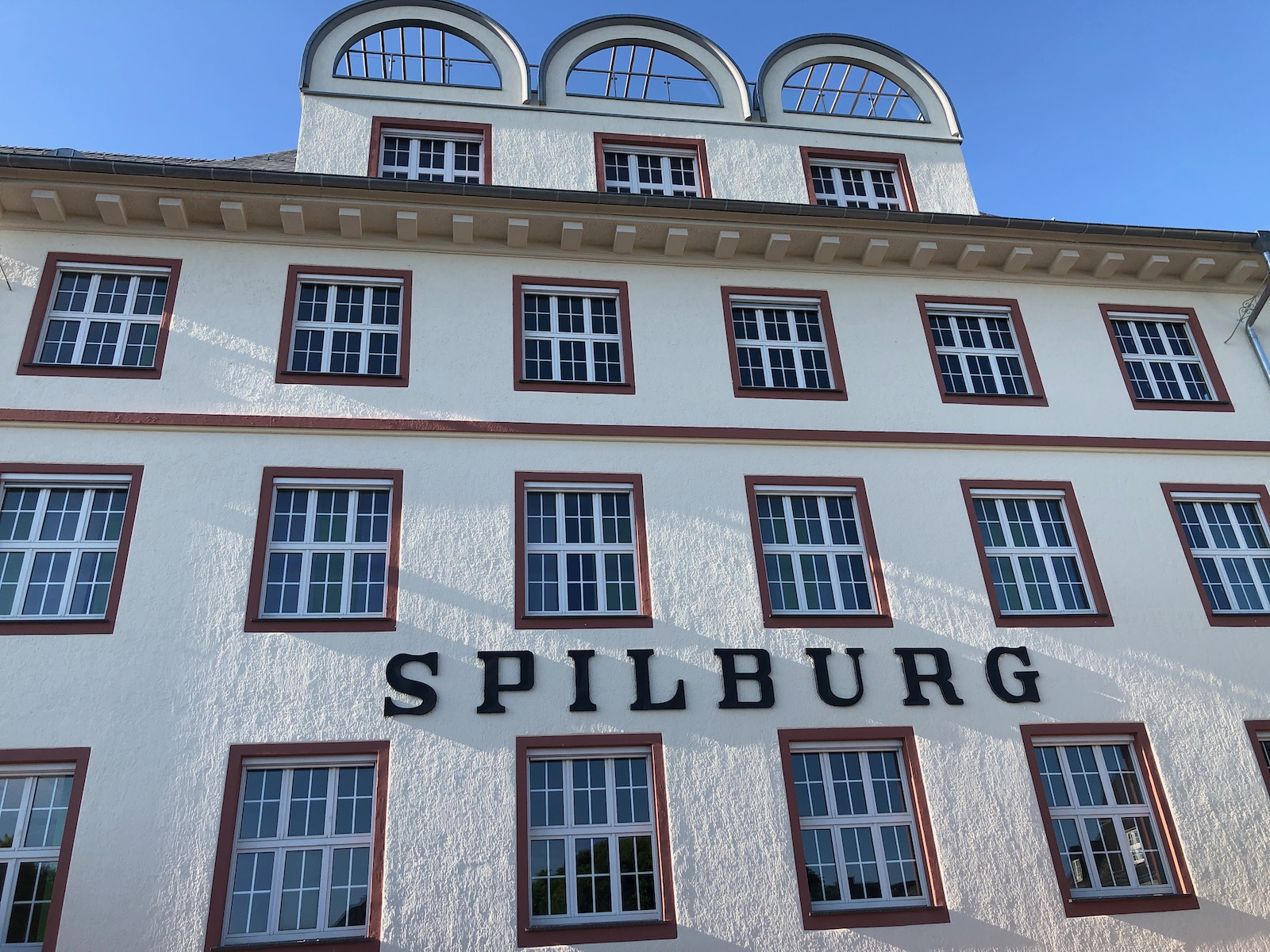 Außenansicht der historischen Spilburg in Wetzlar mit charakteristischen Rundbogenfenstern und Fassaden-Schriftzug – Standort der BETA BOX Spilburg